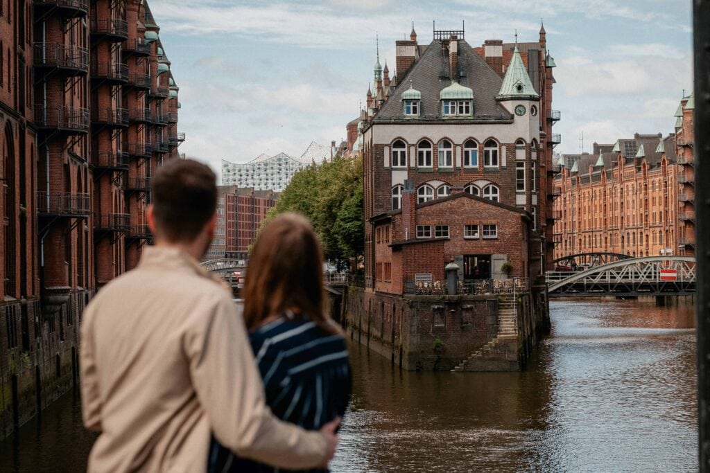 Ein Paar hält sich im Arm. Im Hintergrund ist das Hamburger Wasserschloss zu sehen.